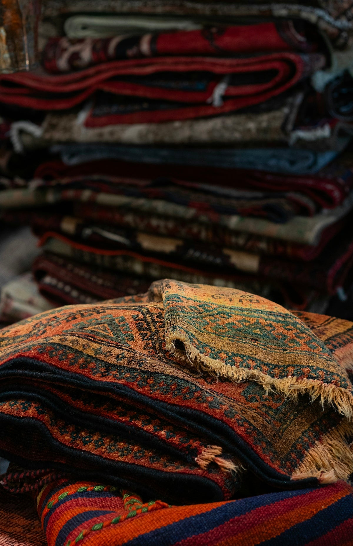 A pile of colorful rugs sitting on top of a wooden table